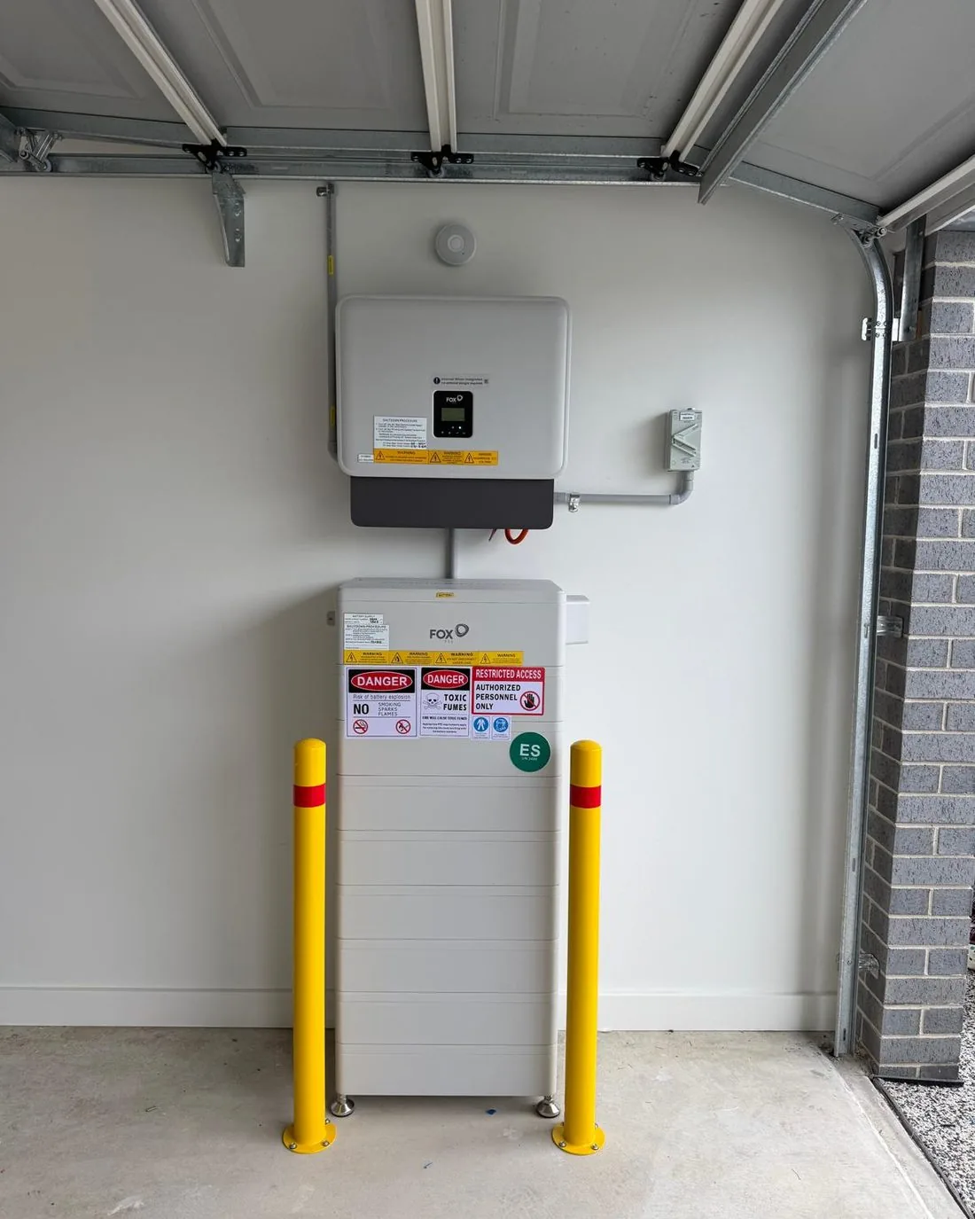 Home battery installed and labelled in a garage