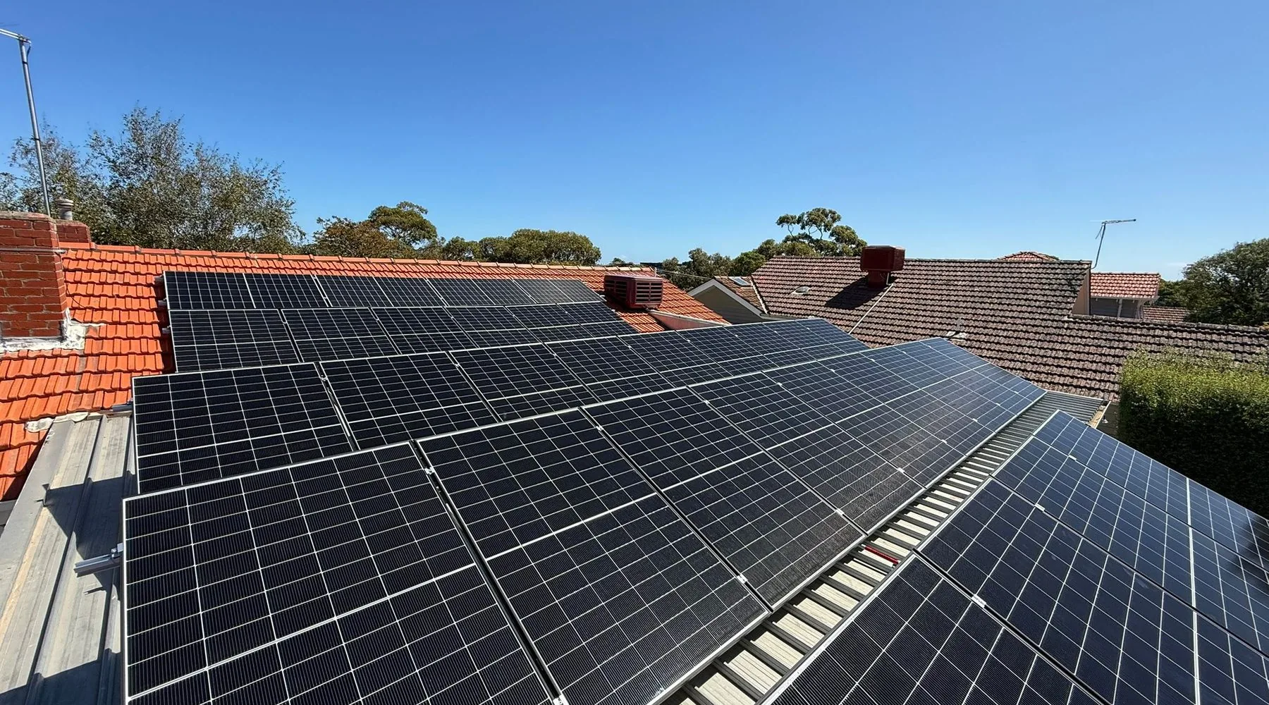 Completed rooftop solar installation under a clear sky